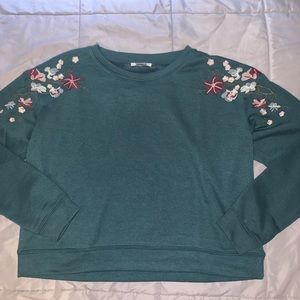 Dark teak sweater with floral design on shoulders
